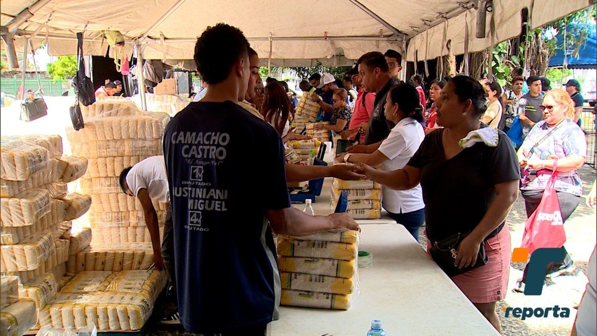 Residents browsing stalls and a health services booth at a community fair in Juan Díaz