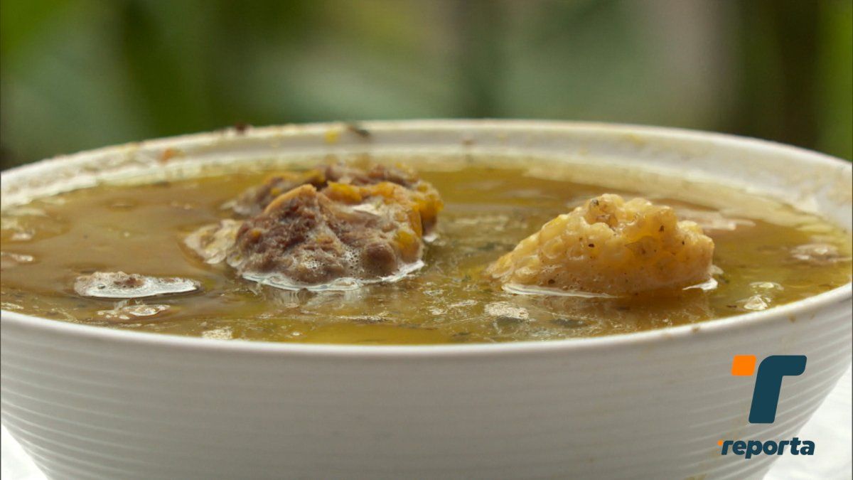 Bowl of Panamanian sopa showing pieces of meat or chicken with vegetables in a home-style setting