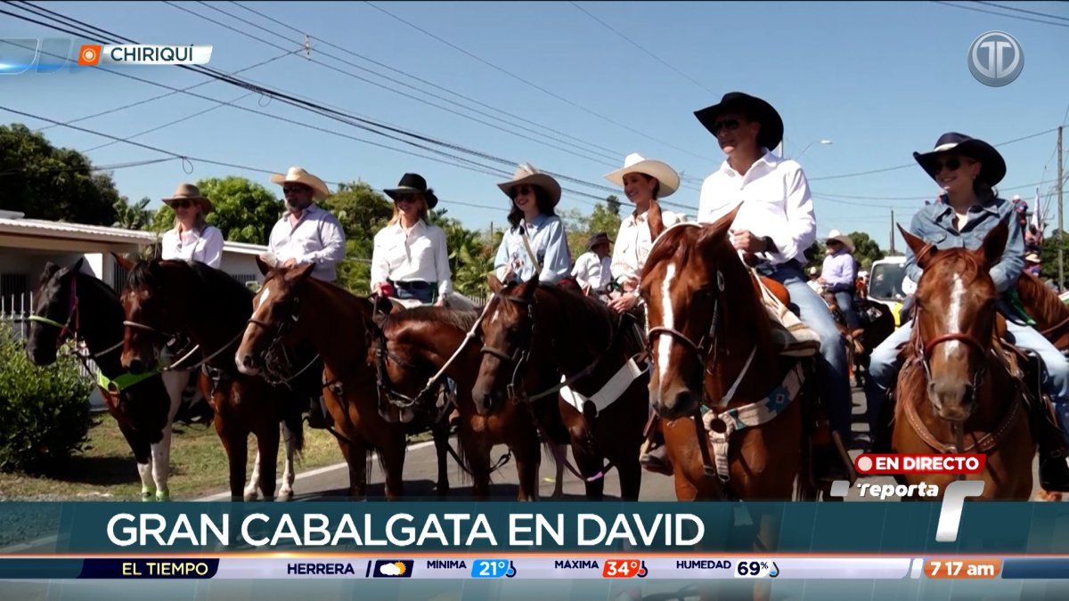 Horseback riders in a large procession during a festival in David, Chiriquí, with crowds watching along the route