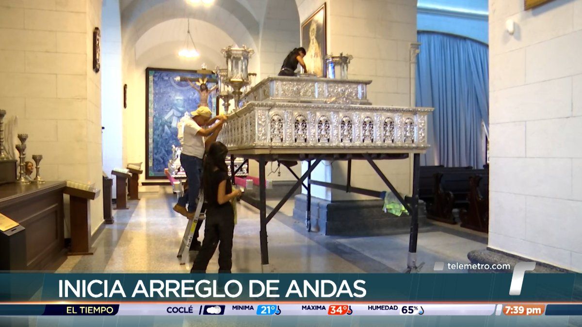Workers repairing wooden processional platforms (andas) in Casco Antiguo with colonial buildings in the background
