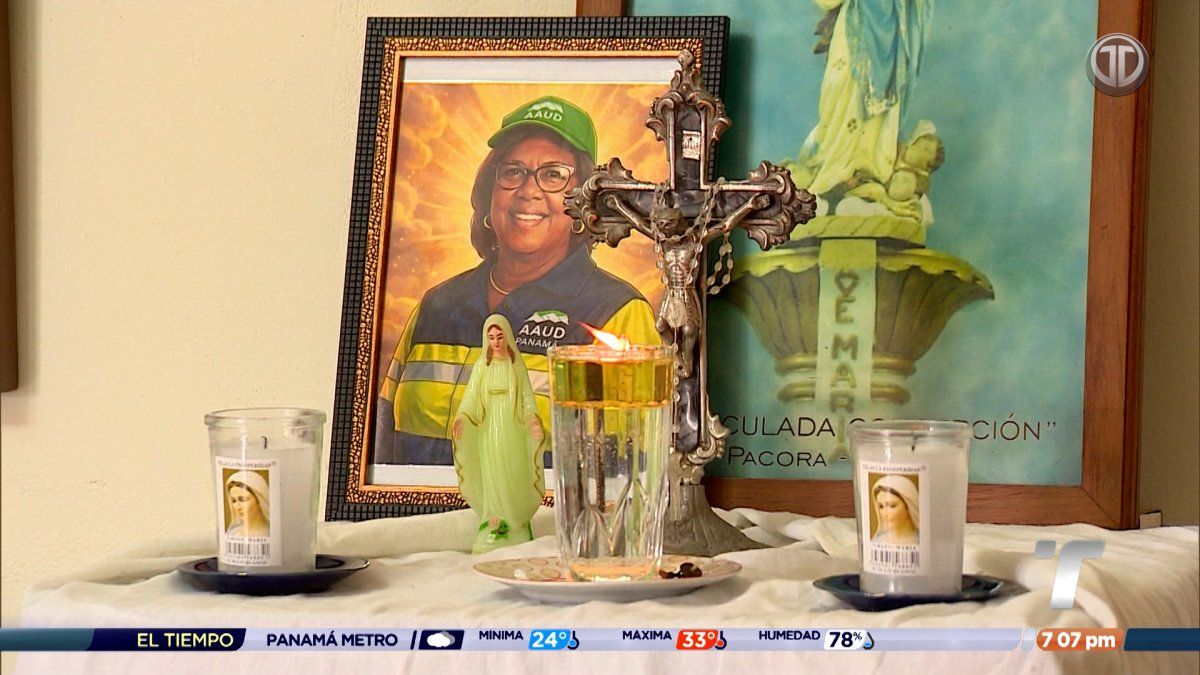 Mourners and colleagues gathered around a casket and floral tributes at the funeral of a sanitation worker in Juan Díaz