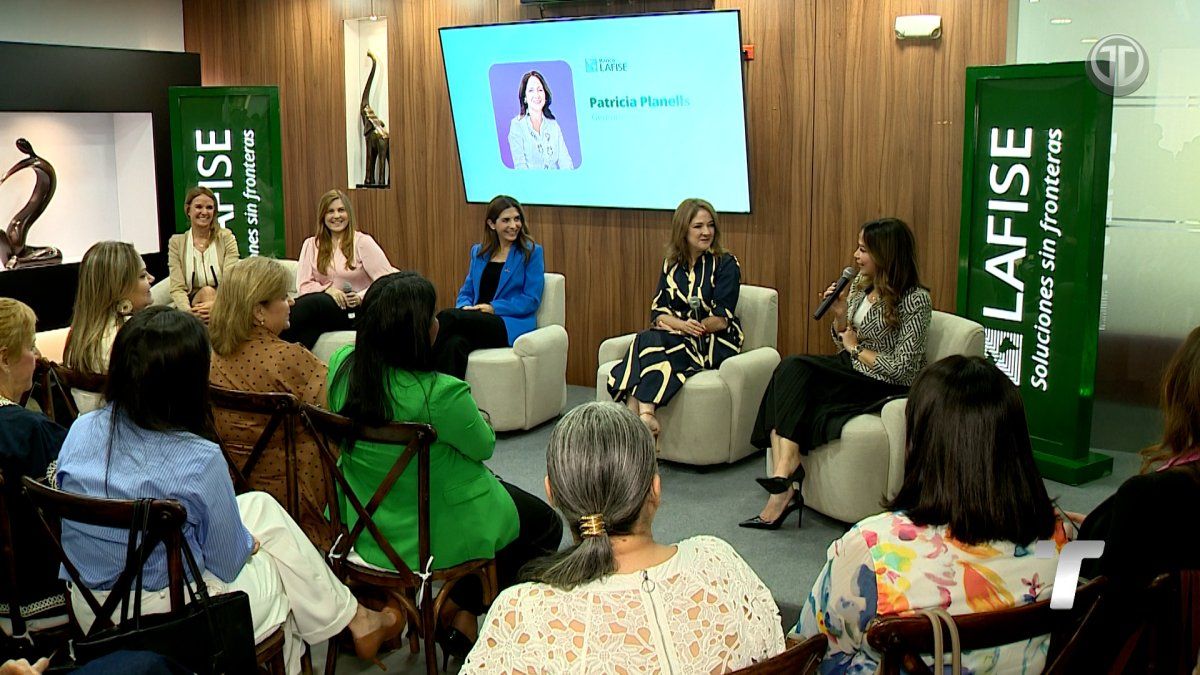 Female leaders speaking on stage at the 'Mujeres que inspiran' forum in Panama with audience and event signage