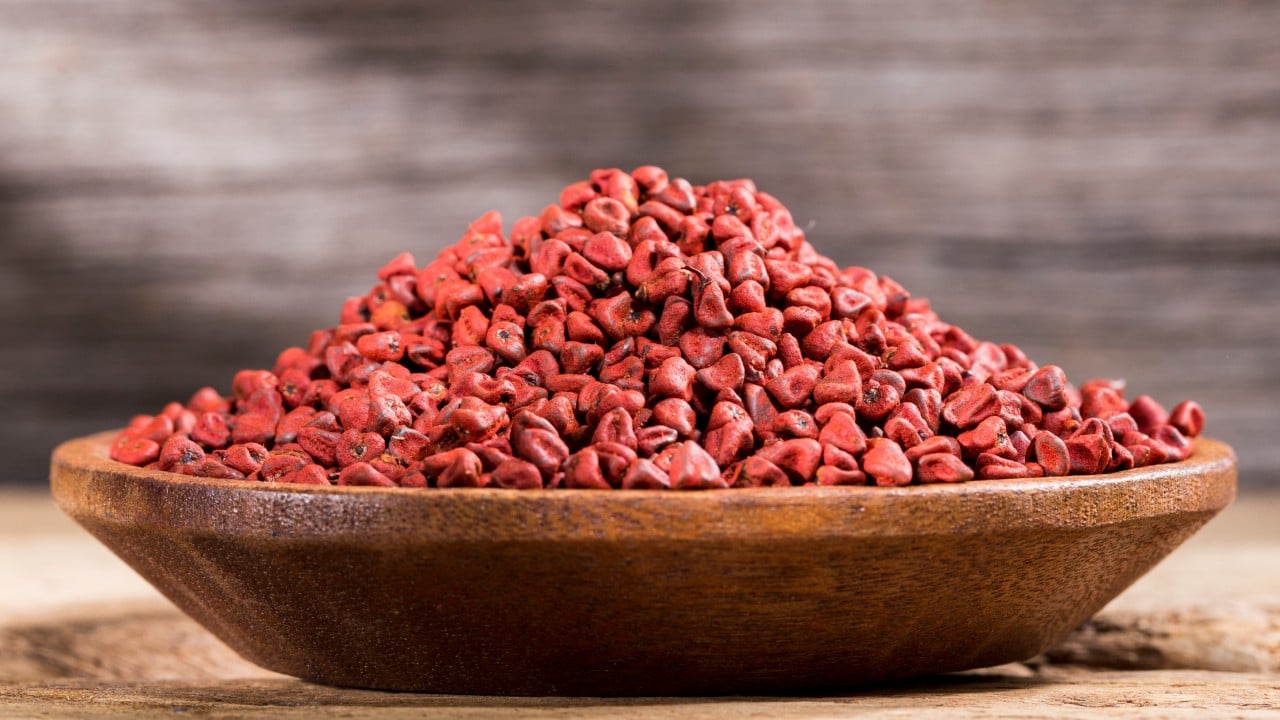 Close-up of annatto seeds and bright red-orange annatto powder used as a natural food dye and spice