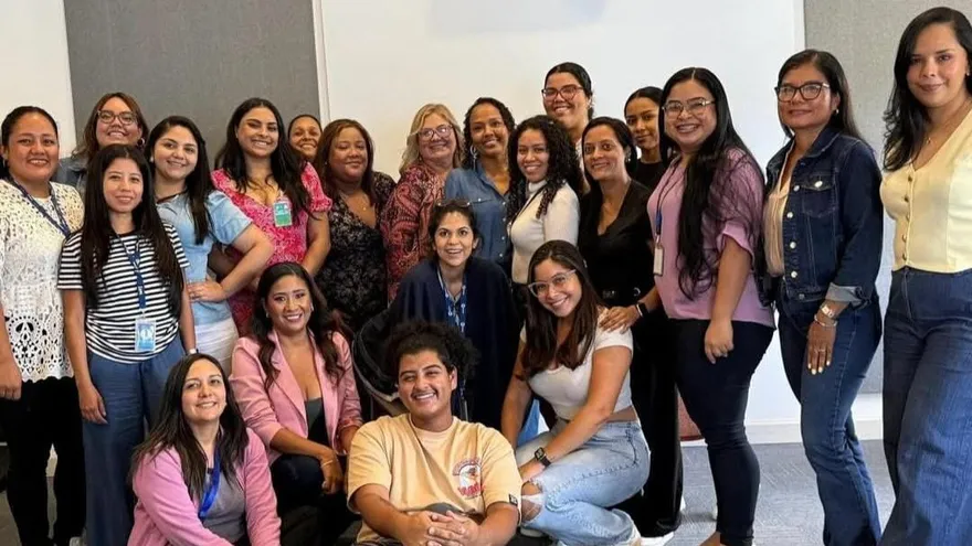 Women participating in a TVN Speed Mentoring session, talking in small groups with TVN signage in the venue