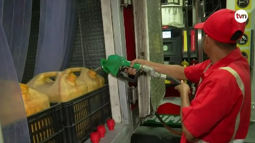 Fuel nozzle at a Panamanian gas station and a container labeled ethanol blend, illustrating bioethanol use in Panama