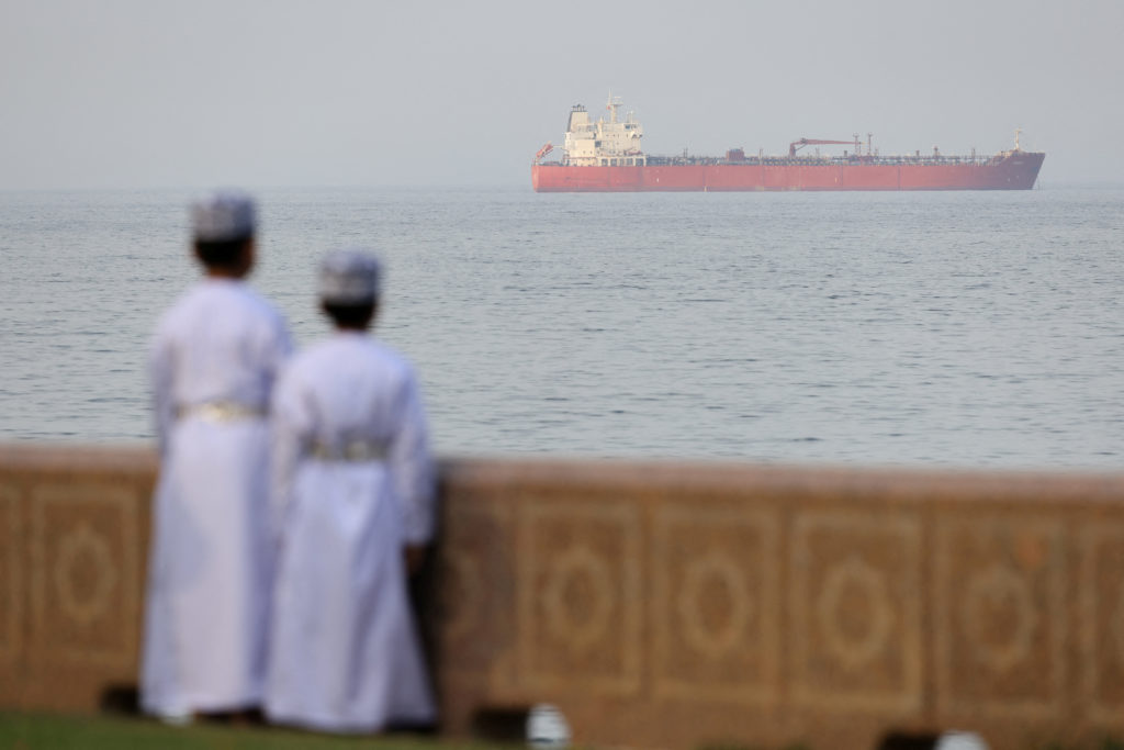 Smoke rising from an offshore gas platform in the Middle East after a reported strike, with emergency response vessels nearby