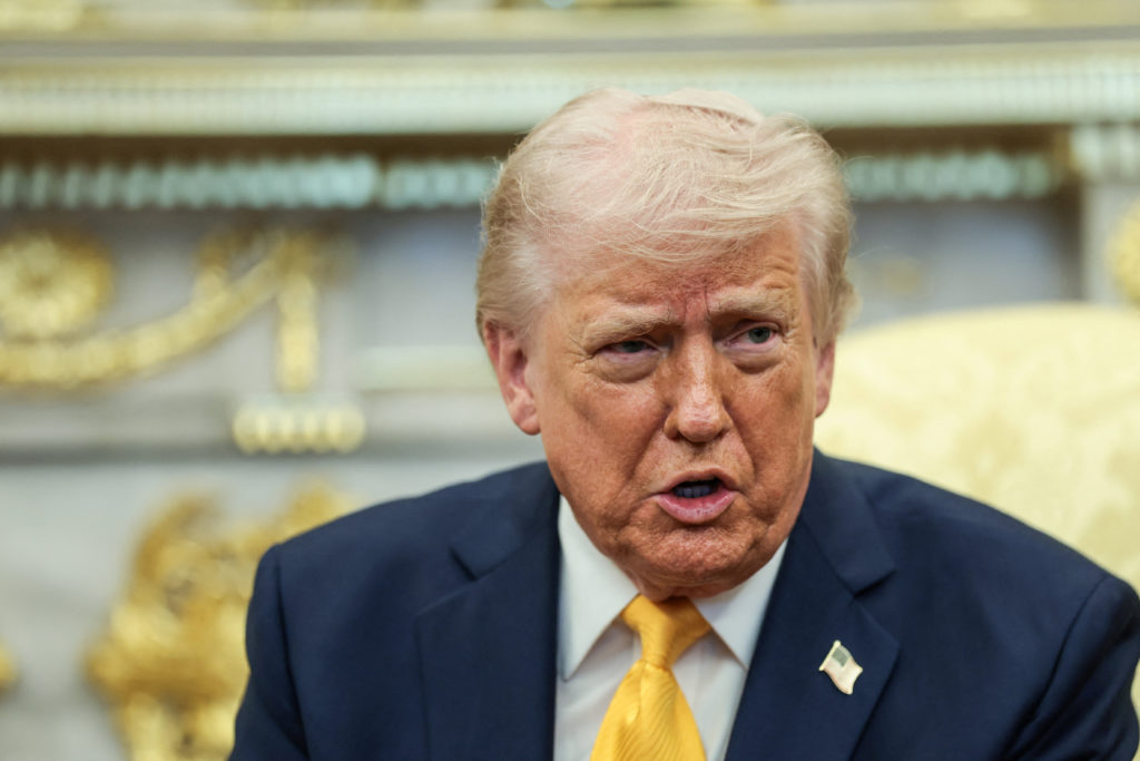 President Donald Trump at a podium with U.S. flag backdrop, symbolizing the decision on deploying troops to seize Iran's near‑bomb‑grade uranium