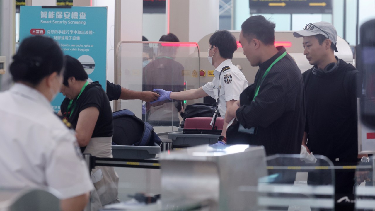 Airport security checkpoint with passengers carrying luggage and portable power banks