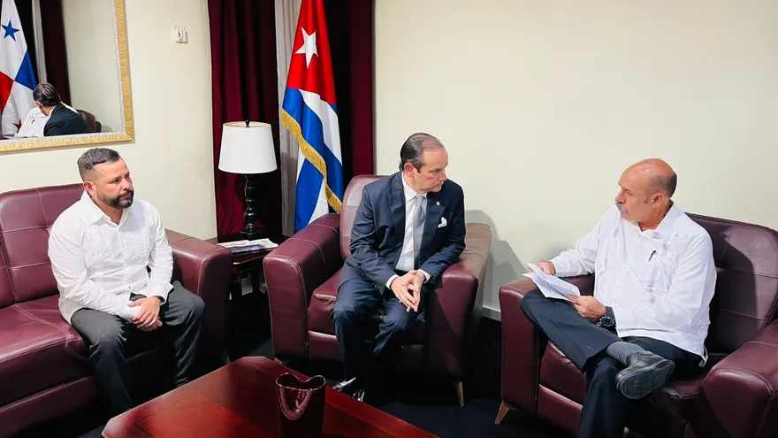 Panama foreign minister meeting a group of Panamanian citizens during an official visit to Cuba with officials present