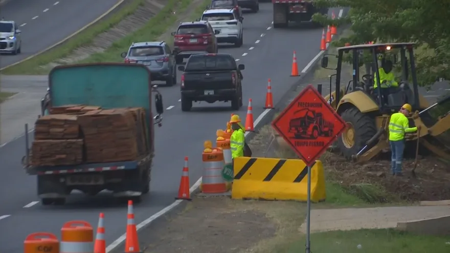 Traffic moving along a Panamanian highway during holiday travel with roadwork signs in the distance