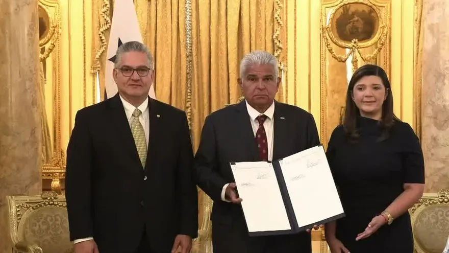 President Mulino signing the paid internships law with young people and officials present