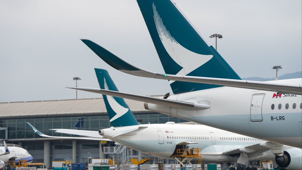 Cathay Pacific aircraft on the tarmac at Hong Kong International Airport with terminal buildings in the background