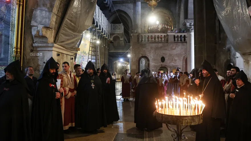 Exterior of the Church of the Holy Sepulchre in Jerusalem with visitors and security presence nearby