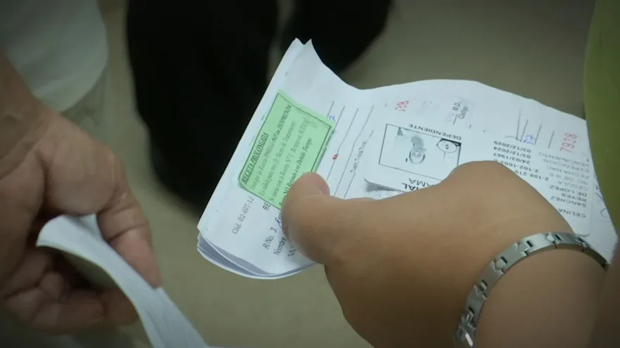A worried patient speaking with a pharmacist while pharmacy shelves show limited medication stock