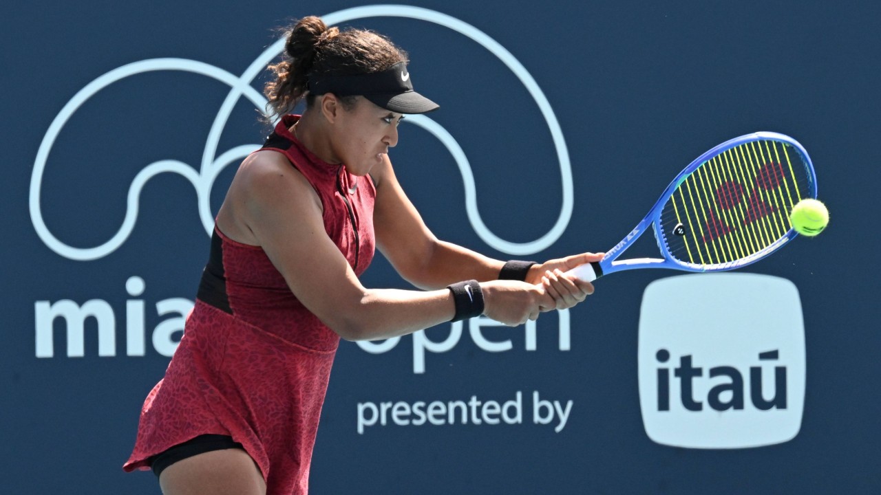 Naomi Osaka on court at the Miami Open, holding her racket and walking after a match