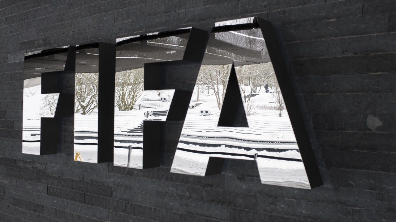Fans queuing outside a stadium and FIFA World Cup signage, representing ticket sales for the 2026 tournament