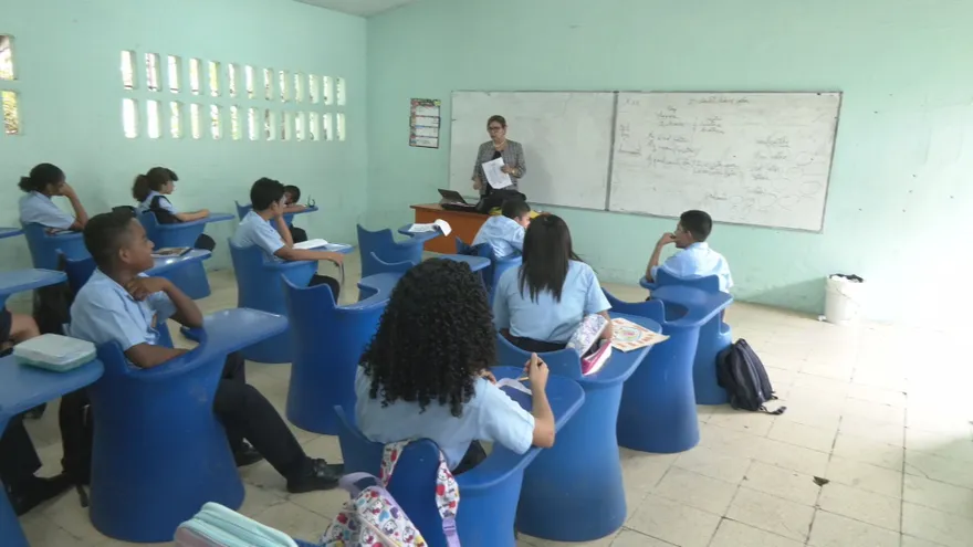Una sesión de evaluación escolar en Panamá con estudiantes usando material de examen y docentes supervisando