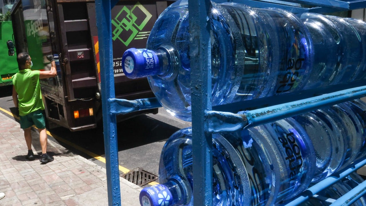 Pallets of Bonaqua bottled water and delivery trucks outside a government office being unloaded