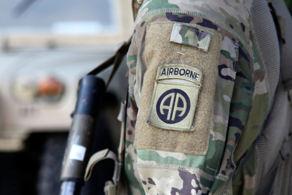 Soldiers of the 82nd Airborne preparing to board a military transport plane for a rapid deployment