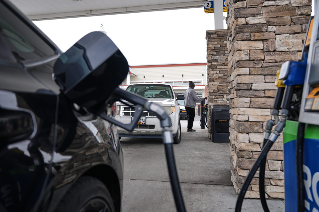 Gas pump nozzle and a fuel dispenser displaying an E15 label at a U.S. gas station