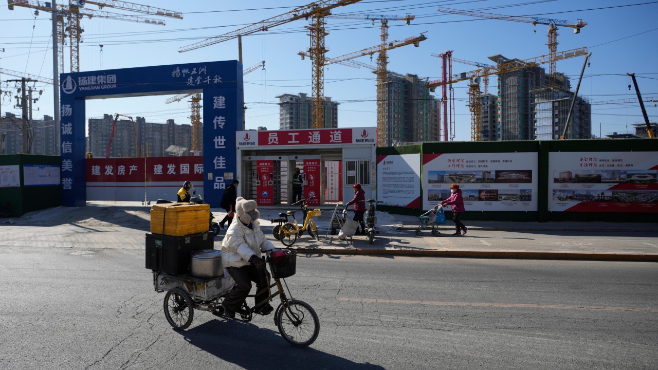 A skyline of Chinese residential high-rise buildings with cranes, suggesting a cautious housing policy stance.