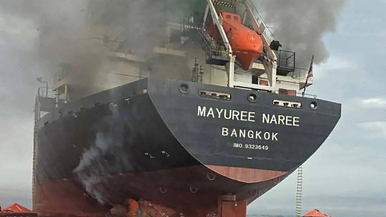 Military vessels and commercial tankers in a narrow shipping lane near the Strait of Hormuz