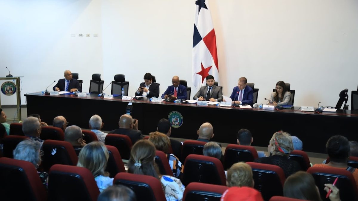 Panama National Assembly session discussing pension legislation, with elderly citizens and lawmakers involved in debate