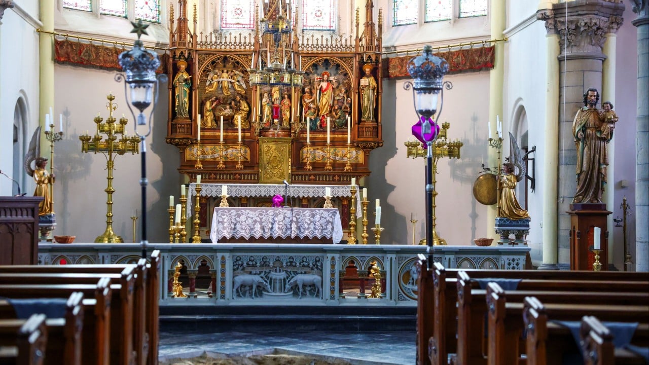 Interior of St Peter and Paul Church in Maastricht where archaeologists examine floor tiles above a newly discovered grave