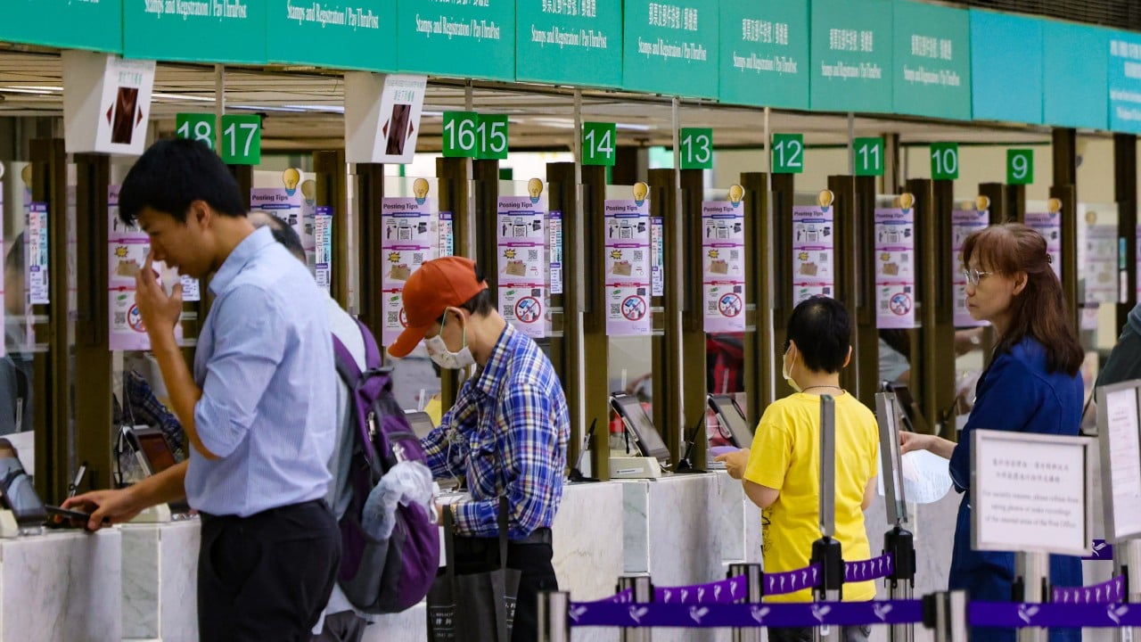 Hong Kong post office counter and mailboxes with a sign about postage rates