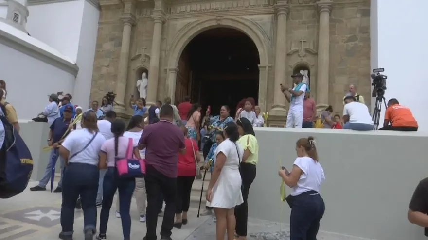 Cofrades and pilgrims processing along the colonial streets of Casco Antiguo during Holy Week, with historic buildings in the background