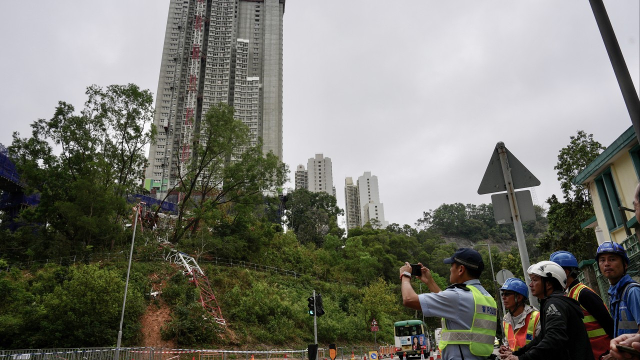 Collapsed tower crane at a construction site with emergency responders and damaged scaffolding at a public housing project in Hong Kong