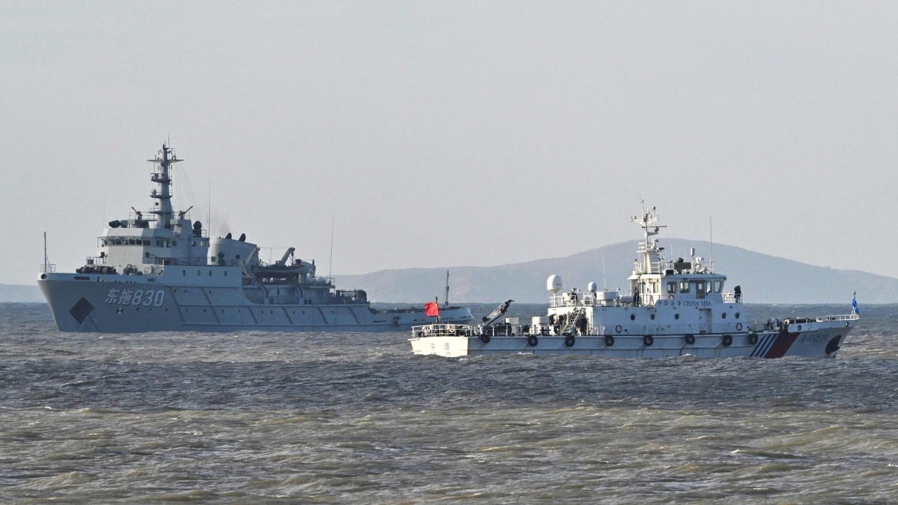 Map outline of Taiwan and mainland China alongside a printed US intelligence report, symbolizing the threat assessment