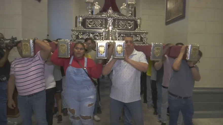 Devotees practicing carrying a heavy religious float (anda) along a narrow street in Casco Antiguo, Panama City
