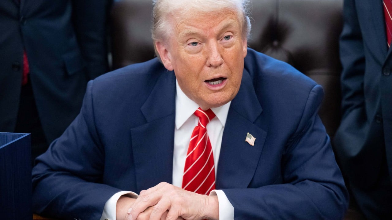 President Donald Trump speaking at a podium announcing an artificial intelligence policy framework, with American flags in the background