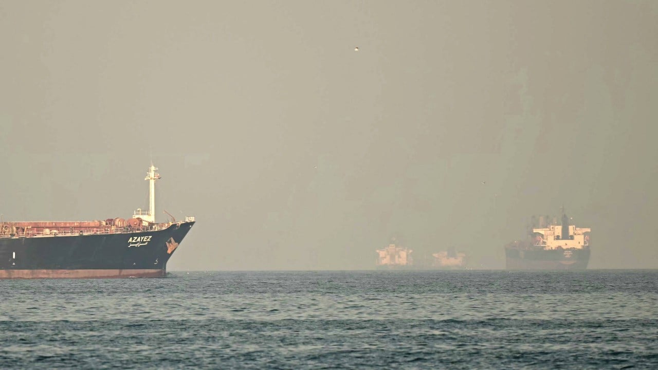 A Japanese Maritime Self-Defense Force warship at sea, with sailors on deck and open waters suggesting operations in a strategic strait