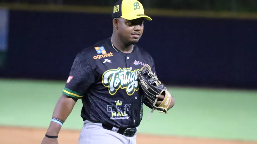Fans in a Panamanian baseball stadium with players on the field and broadcast graphics for TVMAX and TVN Pass
