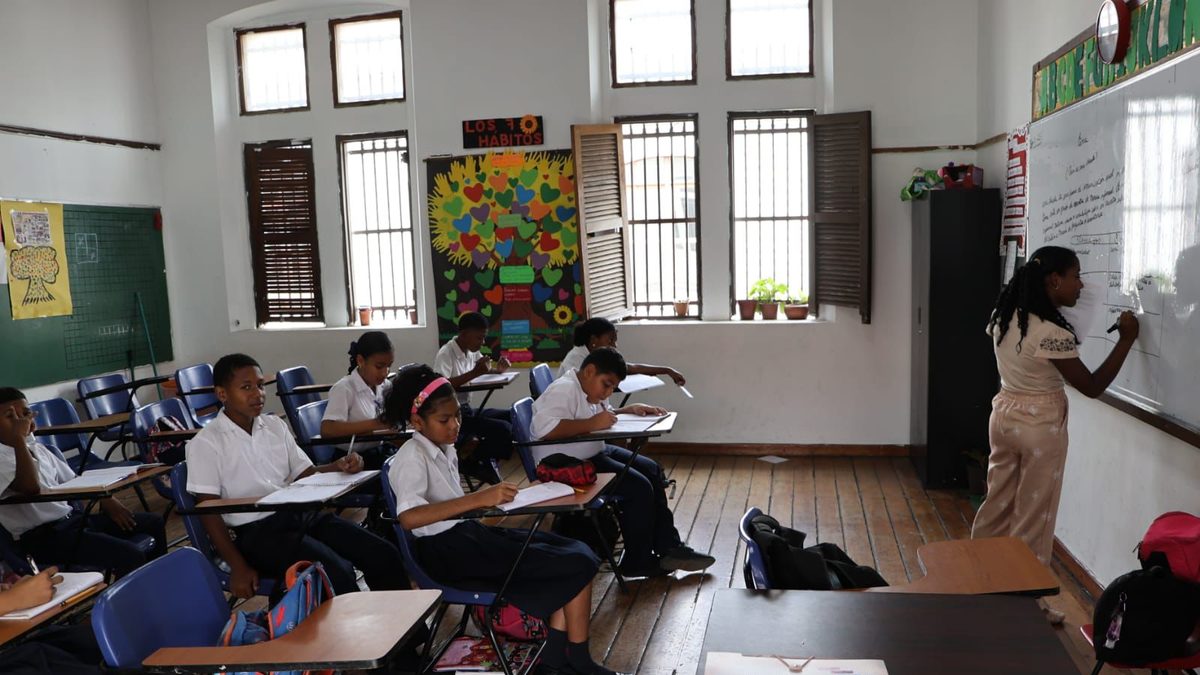 Panamanian students outside a school building with backpacks, representing the end of the school trimester
