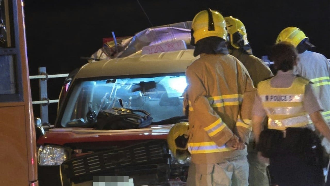 Police and emergency responders at the scene of a fatal bus and taxi crash on a Hong Kong highway at night