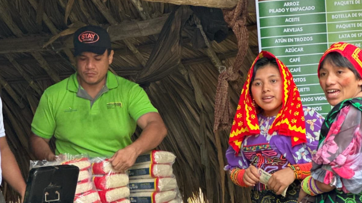 Shoppers and vendors at a Panama agroferia with stalls of fruits and vegetables and IMA signage indicating market activities