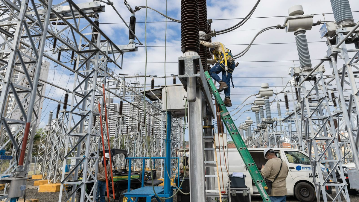 High-voltage electrical transmission lines with Panama city skyline, symbolizing ETESA and green finance in Panama