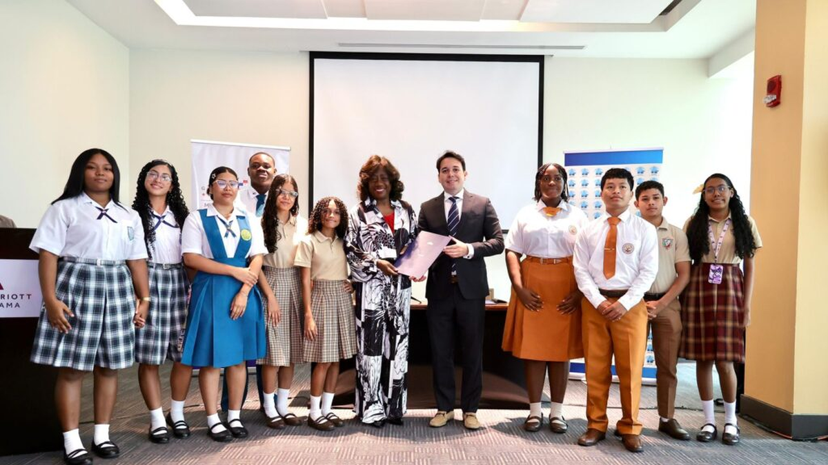 Students in a hospitality training setting with hotel staff demonstrating service techniques