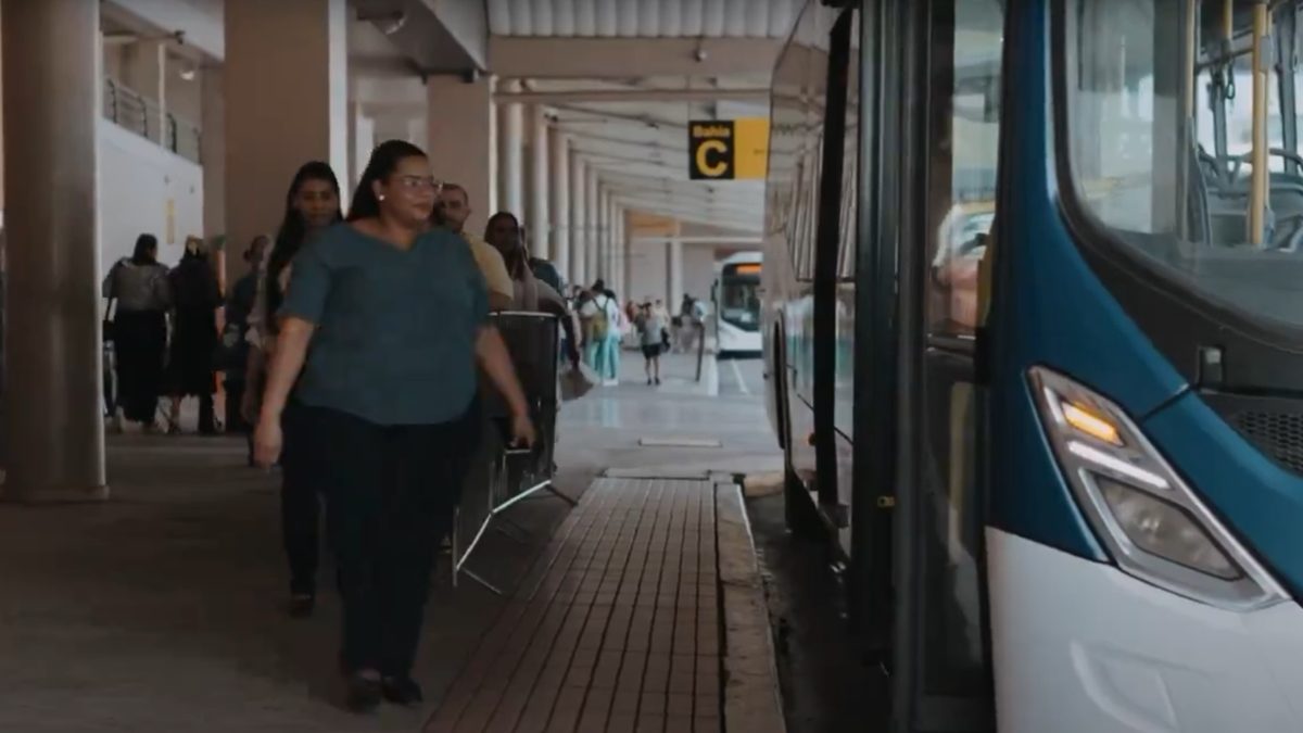 MiBus buses at a city stop with passengers waiting, illustrating public transit service in Panama under revised schedules