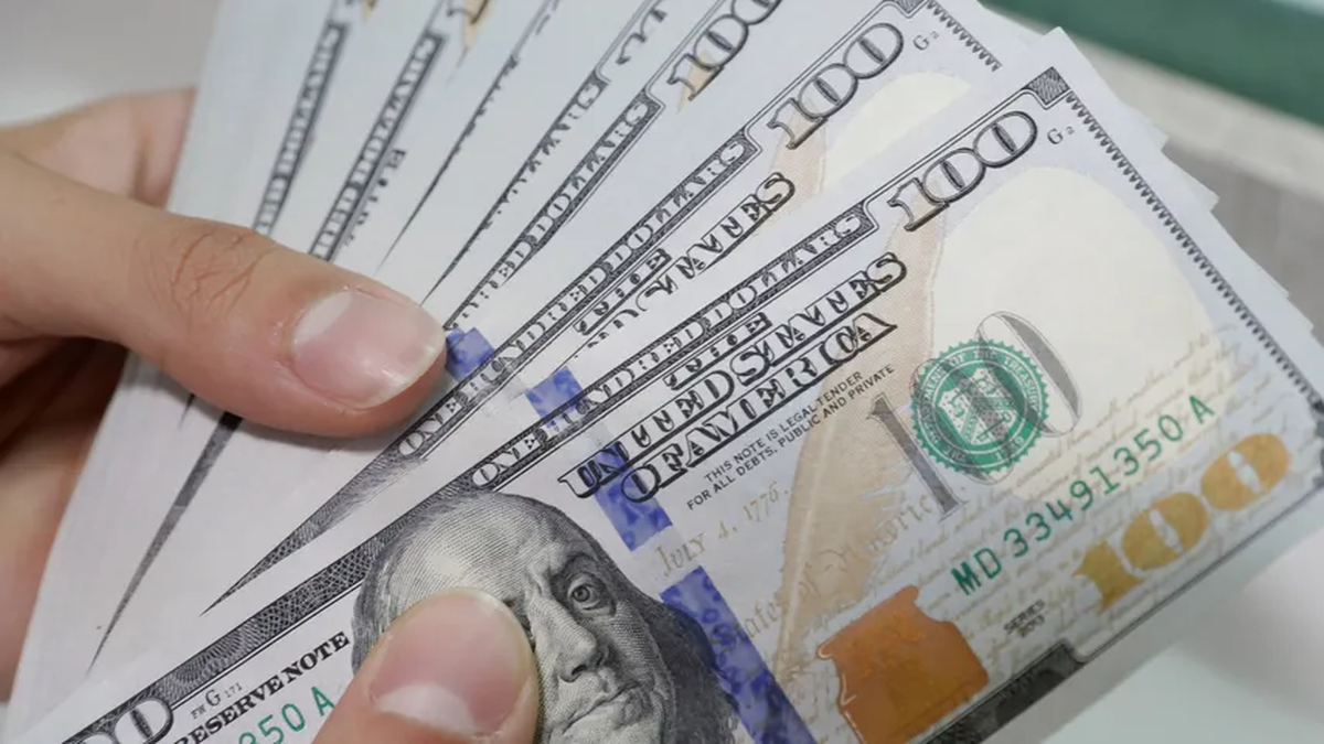 Person using a calculator and reviewing payslips with a Panamanian flag on the desk, illustrating payroll and décimo tercer mes payments