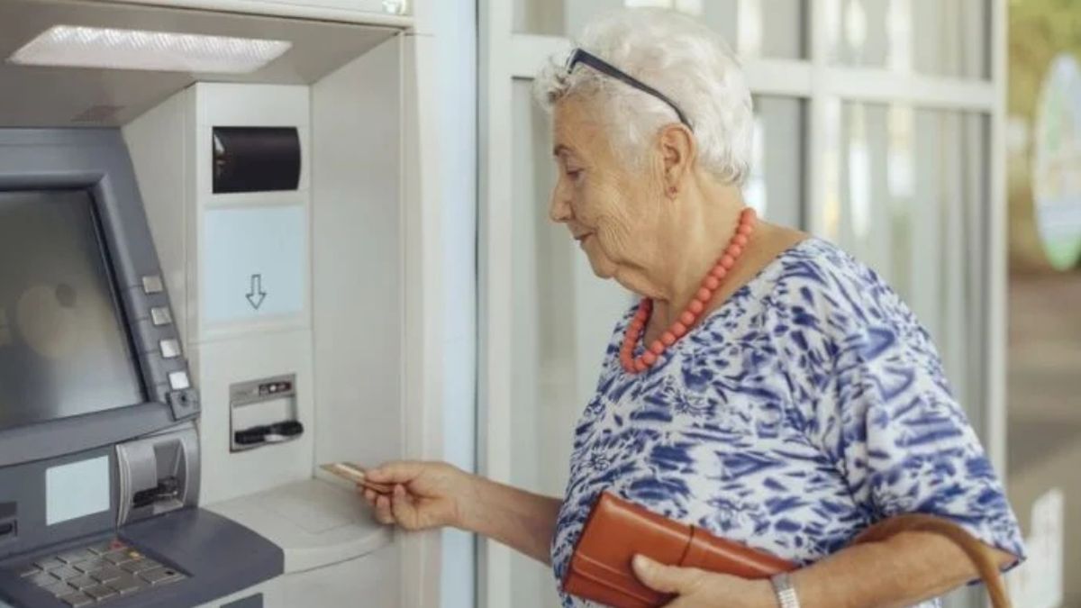 Elderly Panamanian man and woman at a social services office, representing retirees who could benefit from a pension adjustment