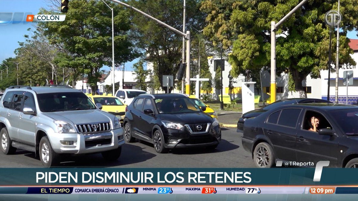 Drivers and vehicles moving through a busy street checkpoint in Colón, Panama