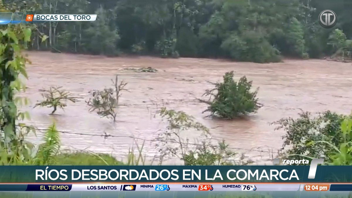 Civil protection personnel monitoring a swollen river in western Panama during rainy weather