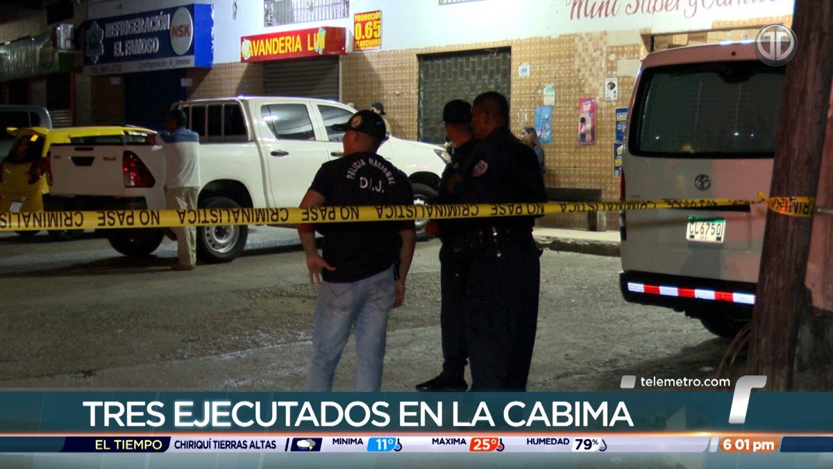 Police officers standing in a public street area in Panama as investigators respond to a violent crime scene