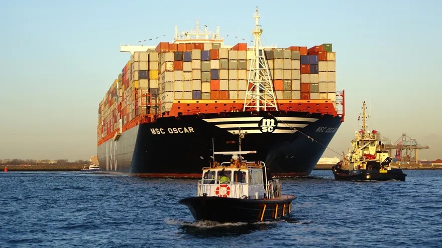 Panama Canal cargo ships moving through a busy lock channel with a container vessel in the background