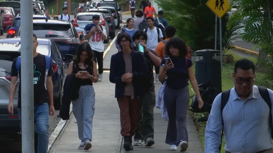 Students speaking with university representatives at a career fair in Panama City with informational booths and guidance activities