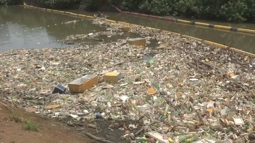 A trash barrier installed across an urban river in Panama to catch floating debris before it reaches the bay